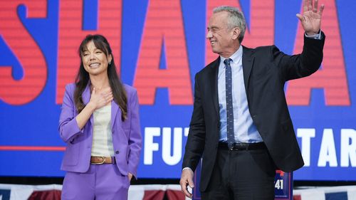 Presidential candidate Robert F. Kennedy Jr. right, waves on stage with Nicole Shanahan, after announcing her as his running mate, during a campaign event, Tuesday, March 26, 2024, in Oakland, California.