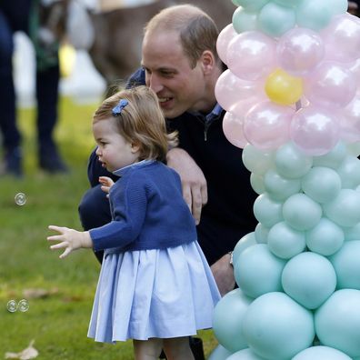 Britain's Prince William and Princess Charlotte look on as Prince George plays with a bubble gun at a children's party at Government House in Victoria, British Columbia, Thursday, Sept. 29, 2016.