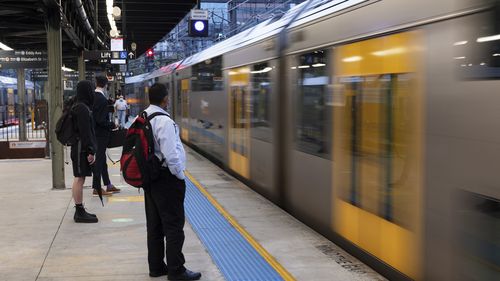 Early morning commuters at Central Station. Metro trains are back running at reduced capacity today, with services on most lines departing every 30 minutes. 22 February, 2022. Photo: Brook Mitchell