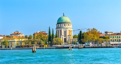 Grand Canal Tempio Votivo War Memorial Church Ferry Dock Restaurants Lido Venice Italy. Tempio Votivo was built between 1925 to 1935 for the War dead and last religious monument in the Venice Lagoon.