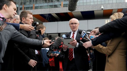 Essendon Chairman Paul Little reads out a statement to waiting media outside the Federal Court in Melbourne where the club and the ASADA were convening. (AAP Image/Joe Castro)