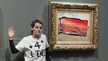 This photo provided by Riposte Alimentaire shows an environmental activist posing by &quot;Poppy Field&#x27;&#x27; by Claude Monet at the Orsay museum, Saturday, June 1, 2024 in Paris. 