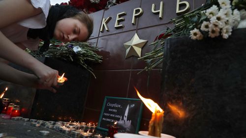 Candles are lit in a makeshift memorial outside Kerch Polytechnic College.