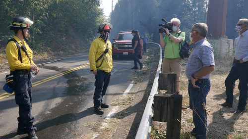 Washington Gov. Jay Inslee, second from right, joins Pierce County Executive Bruce Dammeier, third from right, and East Pierce Fire and Rescue Chief Bud Backer, right, in talking with firefighters, Wednesday, Sept. 9, 2020, during a tour to survey wildfire damage in Bonney Lake, Wash., south of Seattle. (AP Photo/Ted S. Warren, Pool)