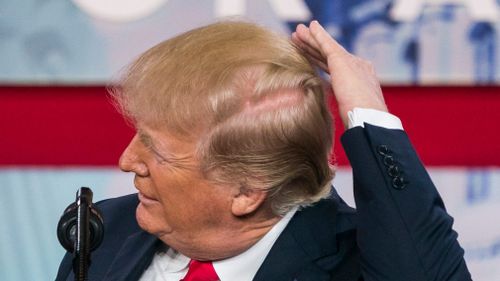 Mr Trump pretends to fix his hair. (AAP)