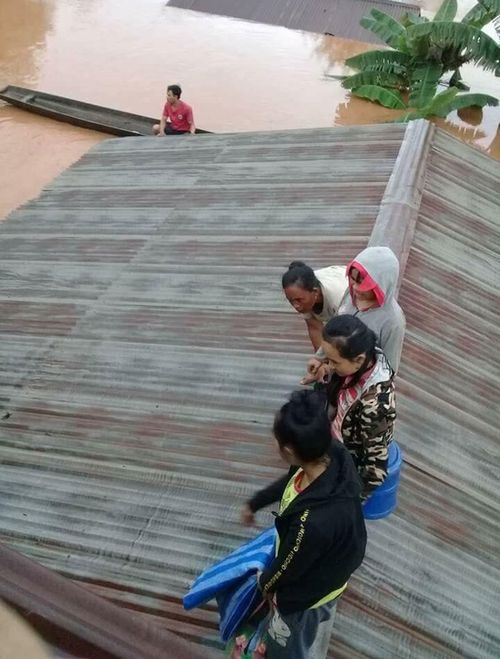 Villagers wait on roofs to be rescued. Picture: AP