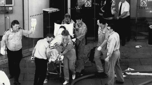 Ambulance officers rush a victim from the NCA's Adelaide headquarters after the parcel bomb explosion in 1994. 