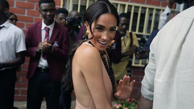 Meghan Markle gestures as she and Prince Harry visit children at the Lights Academy in Abuja, Nigeria, Friday, May 10, 2024.   