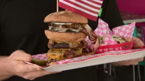 The five-patty burger- with plenty of bacon and cheese- is served. (9NEWS)