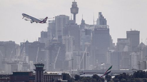 Qantas commercial aircraft taking off across Sydney's skyline photographed From Dolls Point on Botany Bay