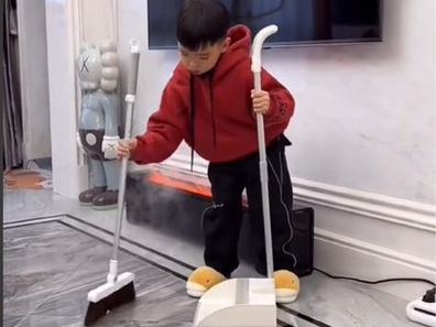 Little boy sweeping with a broom.