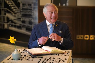 Prince Charles, Prince of Wales signs the visitors book at the re-opening of the Grand Opera house, Belfast, on the second day of a two-day visit to Northern Ireland, on March 23, 2022 in Belfast, Northern Ireland. 