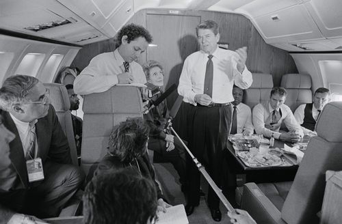 US President Ronald Reagan speaks with the press pool during a flight.