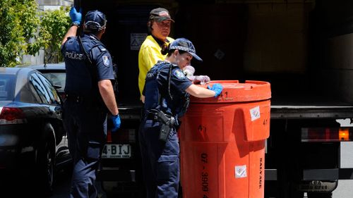 Police remove a bin labelled "toxic" from the Teneriffe apartment. (AAP)