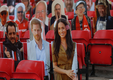 The Duke and Duchess of Sussex appear as cardboard-cut-outs at the football.