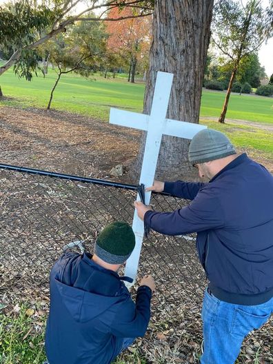 Mr Abdallah and another man rebuilding the memorial for the four children lost in the Oatlands crash.