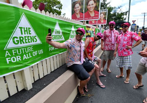  Cricket fans are seen posing for a selfie outside East Brisbane State School polling booth. (AAP)