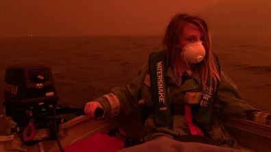 Finn Burns navigates a boat through thick smoke at Mallacoota, as fire advanced on the seaside Victorian town on December 31, 2019.