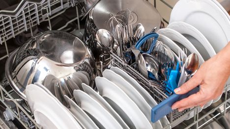 Unloading Dishwasher In The Kitchen