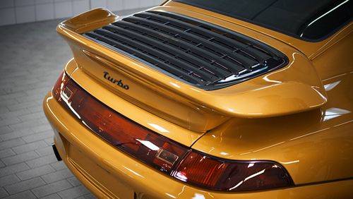 The 993 is air-cooled, necessitating the 'whale-tail' spoiler.