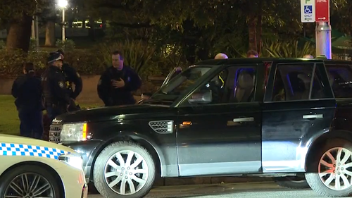 Police officers inspect the allegedly stolen vehicle after a high-speed pursuit through Sydney's CBD.