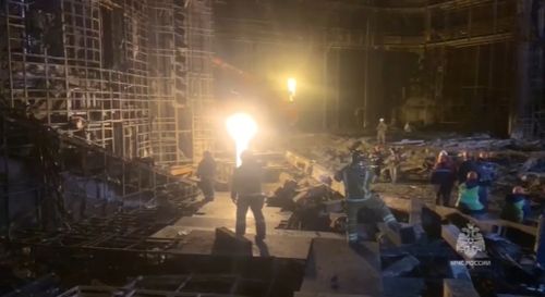 Sur cette photo tirée d'une vidéo publiée par le service de presse du ministère russe des Urgences le mardi 26 mars 2024, des sauveteurs travaillent dans la salle de concert incendiée après une attaque terroriste contre le bâtiment de l'hôtel de ville de Crocus, à l'ouest de Moscou, en Russie.  