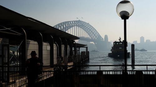 The Sydney Harbour Bridge, seen through a smoke haze from hazard reduction burns across the state of New South Wales, as seen from Circular Quay, in Sydney on May 22, 2016. (AAP)