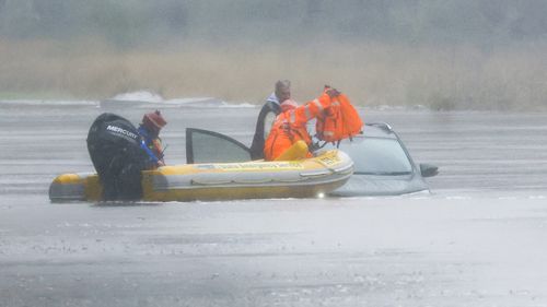 A man is rescued from his car by State Emergency Service workers in Windsor, Sydney.