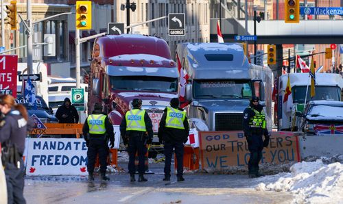 Policemen stand near the truckers sit-in, after the mayor of Ottawa has declared a state of emergency in the Canadian capital after a 10-day-long protest by truck drivers over Covid-19 restrictions that has gridlocked its city center, in Ottawa, Canada, 07 February 2022. 