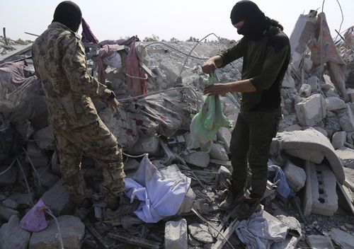 After the American troops retreated, US fighter jets fired six rockets at Abu Bakr al-Baghdadi's house, leveling it. This photo shows people standing on piles of rubble, after US special forces left the site.