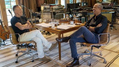 Bruce Springsteen, left, appears with former President Barack Obama during their podcast of conversations recorded at Springsteen's home studio in New Jersey. The eight-episode series covers their upbringings, racism, fatherhood and even recall a White House singalong around a piano.