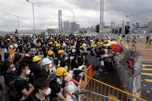 Protesters in Hong Kong pushed barriers and dumpsters into the streets early this morning in an apparent bid to block access to a symbolically important ceremony marking the anniversary of the return of the former British colony to China.