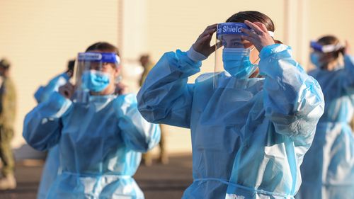 Australian Defence Force members Seaman Chloe Baker and Seaman Tamsin Conway practice correct application of Personal Protective Equipment (PPE) in preparation for their deployment in Task Unit 3, on the Joint Task Force 629.2, Operation COVID-19 Assist