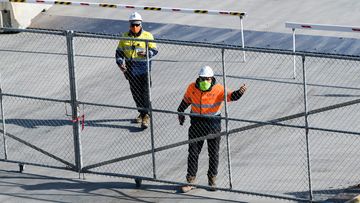 Construction workers on a site in Barangaroo, in Sydney&#x27;s CBD, wear masks to help stop the spread of COVID-19.