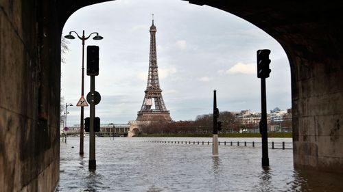 View of the flooded banks of the river Seine in front of the Eiffel tower in Paris, Wednesday, Jan. 24, 2018. The Seine River has overflowed its banks in Paris, prompting authorities to close several roads and cancel boat cruises as water levels rose at least 3.3 meters (nearly 11 feet) above the normal level. (AP Photo/Thibault Camus)