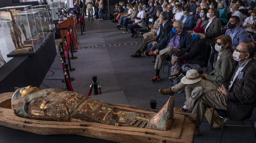 Journalists gather around an ancient sarcophagus more than 2500 years old, discovered in a vast necropolis and Mostafa Waziri, the secretary-general of the Supreme Council of Antiquities, centre, in Saqqara, Giza, Egypt, Saturday, November 14, 2020.