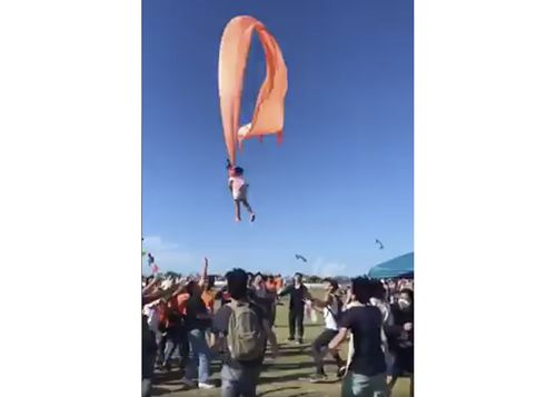 In this image made from video, a 3 year old girl is lifted into the air by a large kite during a kite festival in Hsinchu, northern Taiwan, Sunday, Aug. 30, 2020. The wind slowed down and the girl was safely recovered by adults on the ground. (Credit: Dainese Hsu)