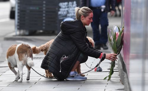 A woman lays flowers after the tourist was killed on Chapel Street. 