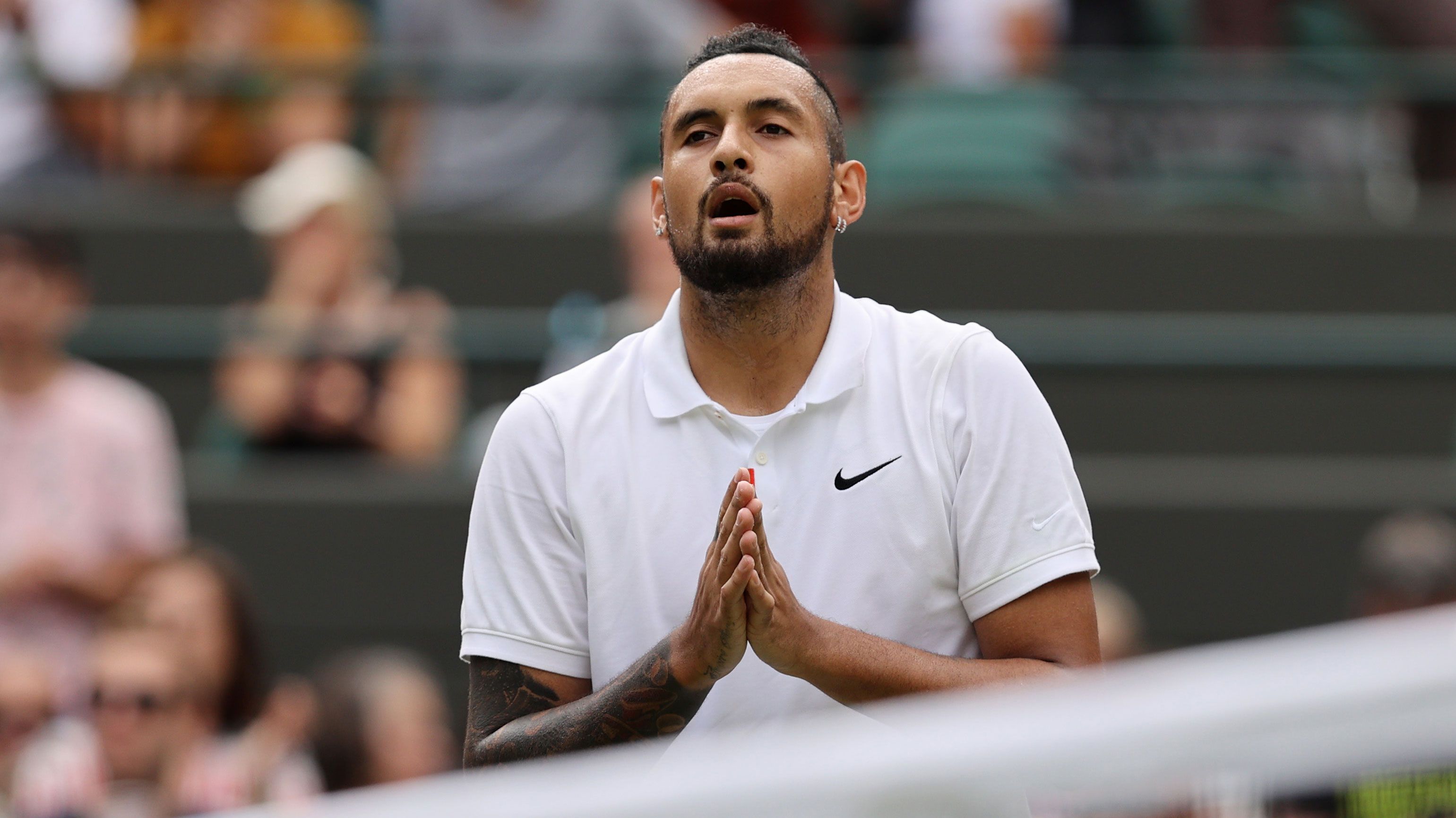 Nick Kyrgios interacts with the crowd after retiring from WImbledon due to injury in 2021.