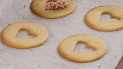 Filling the stained-glass candy cane cookies with crushed candy