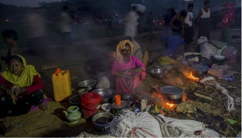 Rohingya Muslims, who crossed over from Myanmar into Bangladesh, prepare a meal in the open at Taiy Khali refugee camp, in Bangladesh on Saturday. (AP)