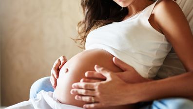 Shot of a husband and pregnant wife sitting together in a bedroom