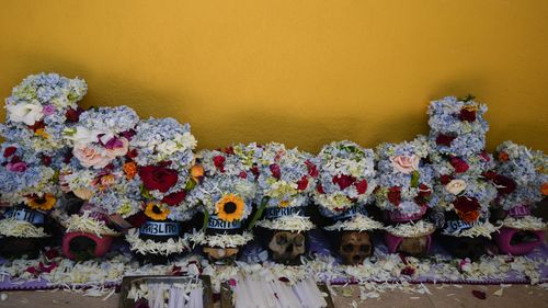 Decorated human skulls lay on the ground at the General Cemetery as part of the annual Ñatitas festival.