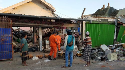 Rescuers inspecting collapsed houses after the earthquake struck in Bali and Lombok.