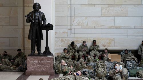 National Guard troops bivouacking on the floor of the US Capitol building.