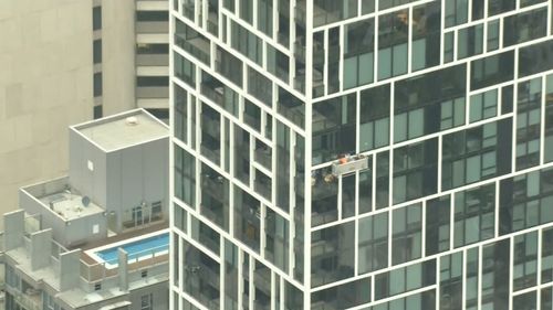 The strong winds left two window cleaners dangling 34 storeys above the ground on Spring Street.