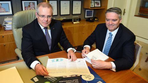 Treasurer Scott Morrison and Minister for Finance Senator Mathias Cormann look at the Budget Papers. (AAP)