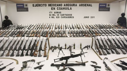 Soldiers stand guard during a media presentation of a weapons cache that includes 154 rifles and shotguns and over 92,000 rounds of ammunition, in Mexico City, in 2011. Authorites believe the weapons belonged to the Zetas drug cartel.