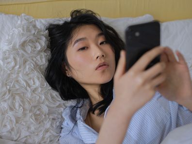 Dating app, digital dating, woman using her phone in bed