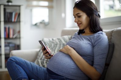 Pregnant woman texting on a mobile phone